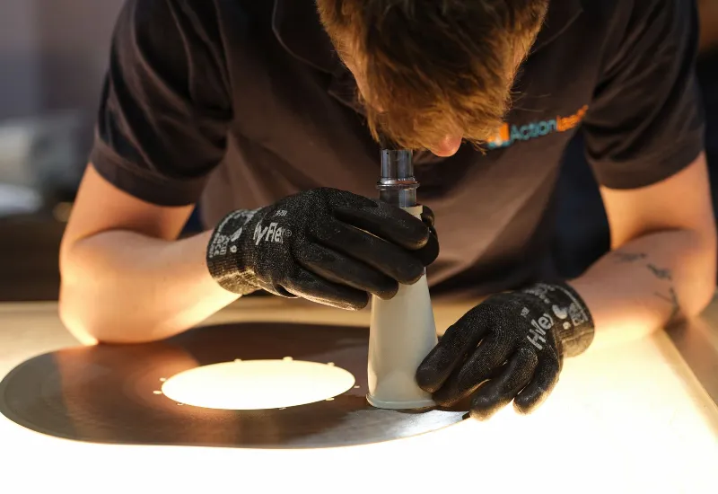 Laser cutting machine cutting a metal sheet with visible sparks during a precision fabrication process.