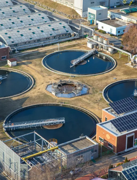 High angle and spring view of round structure of water treatment plant with solar plates